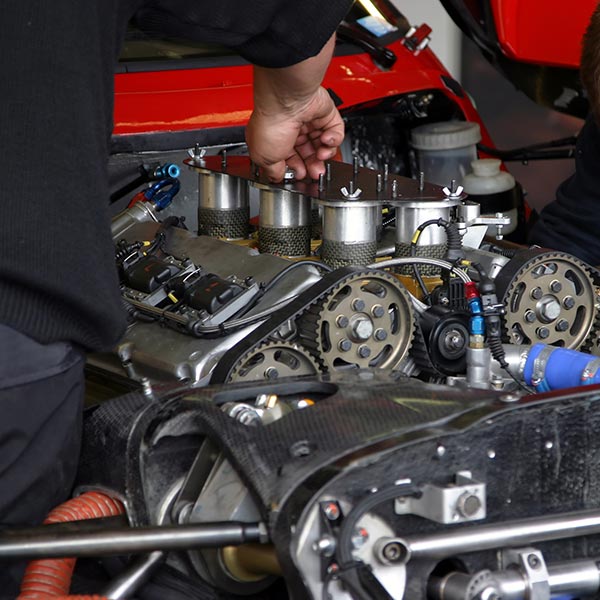 mechanics working on race car engine